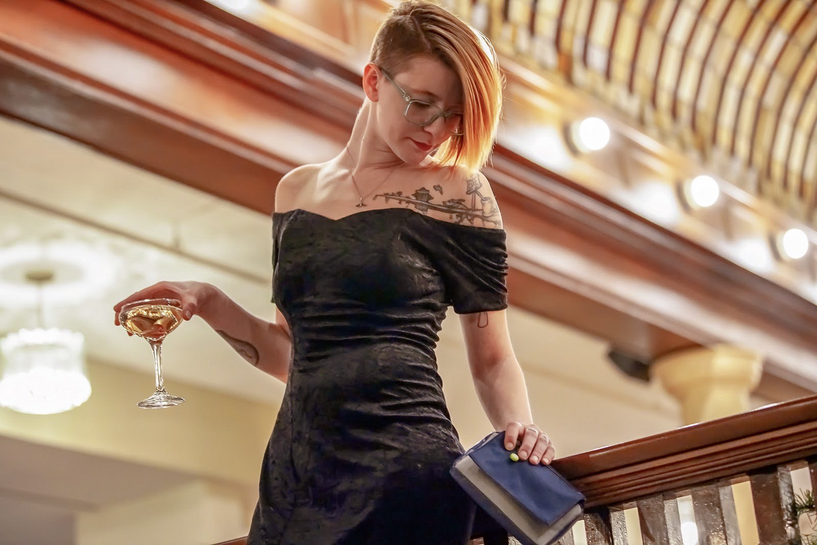 image of woman with stashlogix highland bag in one hand and a drink in her other hand.